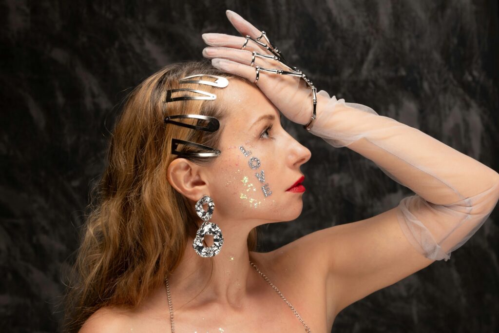 A collection of fashion essentials including a tailored blazer, high-waisted jeans, white sneakers, little black dress, neutral tote bag, statement outerwear, and gold jewelry.