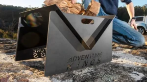 Adventure Kings portable camping fire pit setup on rocky terrain.